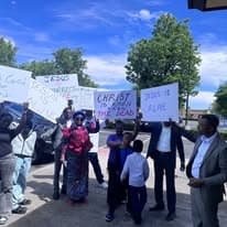Larger group holding Christ is Risen and Jesus is Alive signs
