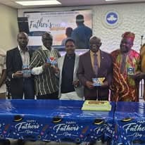 Men in traditional African attire posing with Father's Day gifts